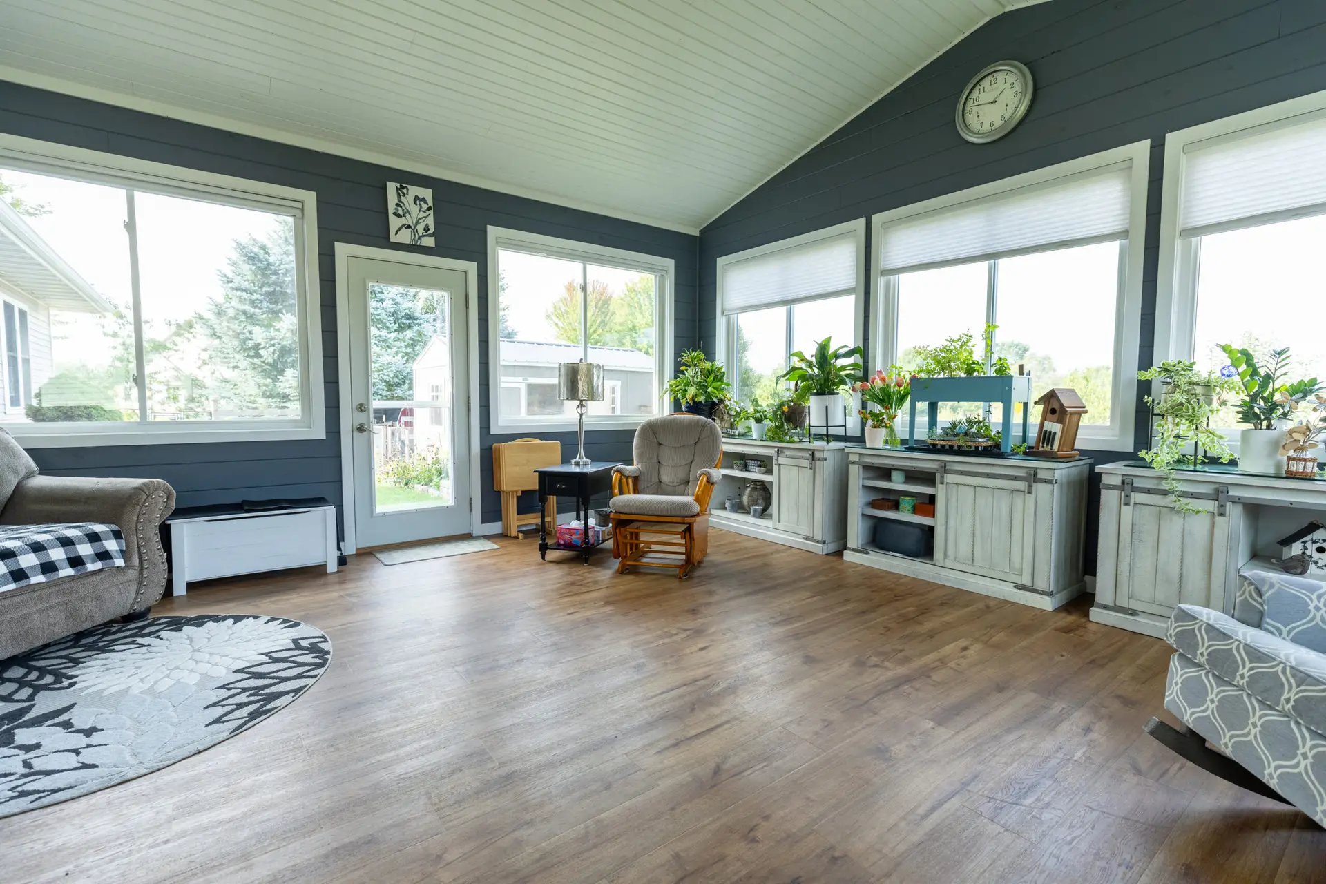 Fond du Lac sun room with blue walls, plants, and LVP flooring